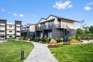 a large house with a garden in front of it at Leafy Lush Resort and Spa in Rāmnagar +26 photos