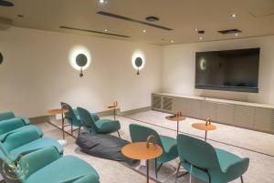 une salle d'attente avec des chaises bleues et une télévision à écran plat dans l'établissement Luxury 2 Bedroom 2 Bathroom Apartment In Wimbledon, à New Malden