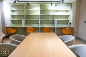 une salle de conférence avec une table et des chaises en bois dans l'établissement Luxury 2 Bedroom 2 Bathroom Apartment In Wimbledon, à New Malden