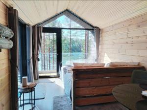 a room with a bed and a large window at Hossaville Luxe Lake Cabin in Hossa