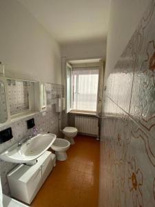 un bagno con lavandino, water e finestra di PM Via 15 Colombo - Andora a Marina dʼAndora