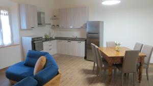 eine Küche und ein Esszimmer mit einem Tisch und einem blauen Sofa in der Unterkunft Casale Poggimele in Empoli