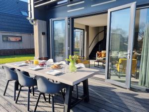 einen Esstisch und Stühle auf einer Terrasse mit Glasschiebetüren in der Unterkunft Luxurious detached water villa with jetty in Balk