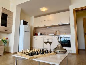 a chess board and wine glasses on a table in a kitchen at Cosher Gardenia Palace Apt 6 Free Parking in Pomorie +28 photos