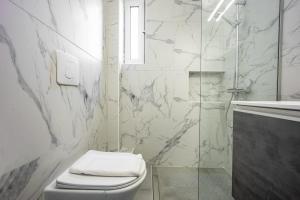 a white bathroom with a toilet and a shower at Varkizaki by the sea in Varkiza +11 photos