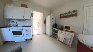 a kitchen with a white stove and a refrigerator at Medstugans Pilgrimsboende in Medstugan