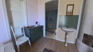 a bathroom with a sink and a toilet and a chair at Medstugans Pilgrimsboende in Medstugan +6 photos