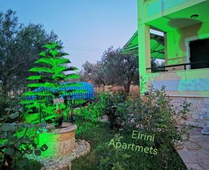 a christmas tree in a garden next to a house at Studio Apartments Eirini in Pyrgi Thermis