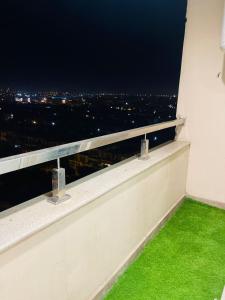 a balcony with a view of a city at night at Gold Crest Luxury Signature Serviced Hotel Apartments DHA Phase 4 Lahore in Lahore