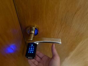 une personne tenant une poignée de porte avec télécommande dans l'établissement Cosher Gardenia Palace Apt 6, à Pomorie