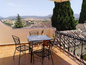a table and chairs on a balcony with a view at Baraka Boutique Pensión in Ronda