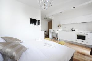 een witte kamer met een bed en een keuken bij Primera Luxury Studio in Zadar