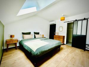 a bedroom with a large bed and a skylight at Gîtes des Bourguerins - Hébergement de charme & Etape Motards in Menotey