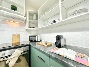 a kitchen with white cabinets and a counter top at LO CAMIN - Cosy - Plain-Pied - Hyper Centre in Mont-de-Marsan