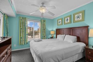 a bedroom with a bed with blue walls and a window at A Place at the Beach III in Atlantic Beach +34 photos