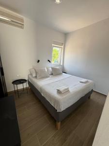 a bedroom with a bed and a window at Apartmani Antonela in Seline