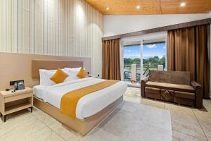 a bedroom with a bed and a chair and a window at Leafy Lush Resort and Spa in Rāmnagar