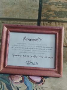 een ingelijste foto van een gedicht in een houten lijst bij Quinti in La Rioja