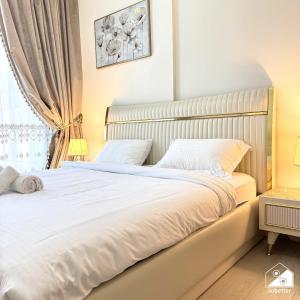 ドバイにあるStylish Pool View 1BR l Central Medyan Escapeの白いシーツと窓のあるベッドのある寝室
