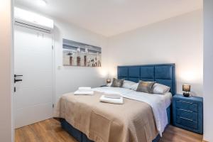 a bedroom with a large bed with a blue headboard at City Premium Heritage in Zadar