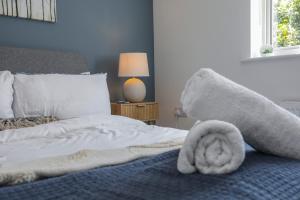 a bedroom with a bed with a towel on it at 8 Iris Cottage, Coastal Hideaway - Suffolk in Wenhaston