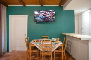 une table et des chaises dans une cuisine avec un tableau mural dans l'établissement Suite Semiramis, à Corfu