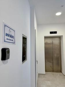 um corredor com uma porta e um sinal na parede em Sunset & Sage studio Santorini Resort em Himare mais 24 fotografias