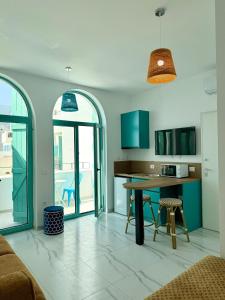uma cozinha com uma mesa e algumas cadeiras e janelas em Sunset & Sage studio Santorini Resort em Himare