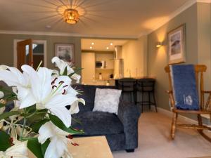 a living room with a couch and a table with white flowers at Brantwood Cottage in Keldhead