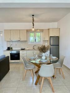 a kitchen with a dining room table and chairs at Aura Seaside Afrathias in Kalamaki