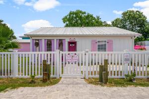 a pink and white house with a white fence at Pink Prerogative Beach Bungalow with Private Pool in Panama City Beach