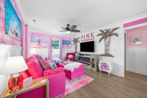 a pink living room with a pink furniture and a tv at Pink Prerogative Beach Bungalow with Private Pool in Panama City Beach
