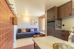 a kitchen and a living room with a couch at L'Observatoire Sauvage - Climatisation - Nature - Insolite - Amboise in Amboise