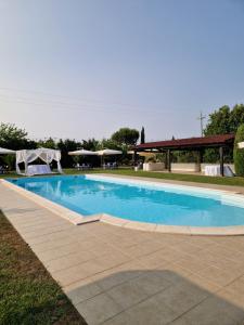 a swimming pool in a yard with a pavilion at Il Casale Mancini in Vada +6 photos