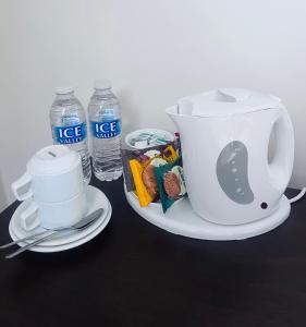 a tea pot on a plate next to two bottles of water at Lambert House in Hull +21 photos