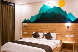 a bedroom with two beds with a mountain mural on the wall at Dharamkot Outlook in Dharamshala
