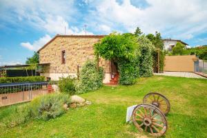 ein Steinhaus mit einem Rad in einem Hof in der Unterkunft La Casa Del Sole in Casamaggiore