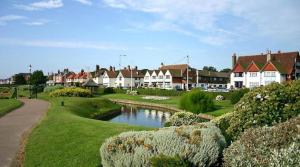 a village with houses and a river in the foreground at The Kensington in Great Yarmouth