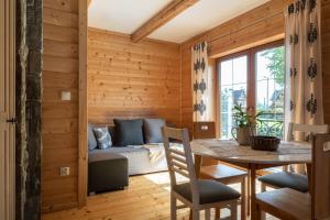 a room with a bed and a table and a bed and a window at Domek, Apartamenty i pokoje Willa Elita in Kościelisko