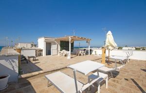 a patio with white tables and chairs and the ocean at Lovely Apartment In Villanova With Wifi in Villanova di Ostuni +16 photos