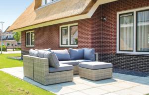 a couch sitting on a patio in front of a house at 4 Bedroom Nice Home In Idskenhuizen in Idskenhuizen