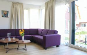 a living room with a purple couch and a table at 4 Bedroom Nice Home In Idskenhuizen in Idskenhuizen