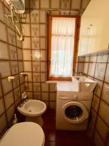 ein kleines Bad mit einem WC und einer Waschmaschine in der Unterkunft Villa Marina in Fort Village