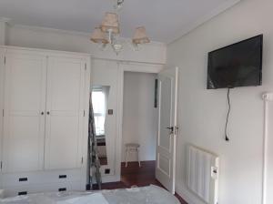 a white room with a tv on a white wall at Habitación individual cerca Bilbao in Sestao