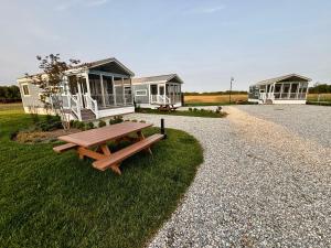 a picnic table sitting in the grass next to houses at The Retreat at King Cole Farm in Dover