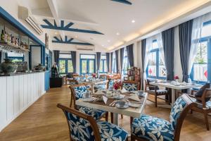 a restaurant with tables and chairs and windows at Somewhere Koh Sichang in Ko Si Chang