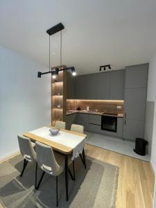 Una cocina con una mesa y sillas en una habitación. en Apartman Vida, en Trebinje