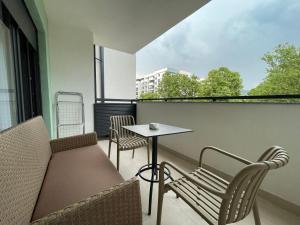 Un balcón con un sofá, una mesa y sillas. en Apartman Vida, en Trebinje