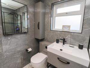 une salle de bain avec toilettes, lavabo et fenêtre dans l'établissement Rose Cottage, à Alnwick 42 autres photos