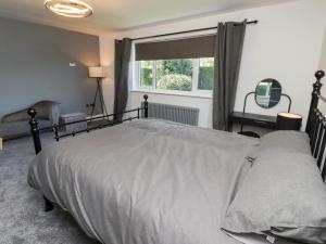 une chambre avec un grand lit et une fenêtre dans l'établissement Rose Cottage, à Alnwick